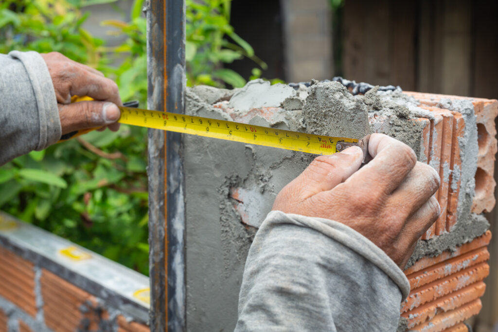 bricklaying. construction worker building a brick wall.